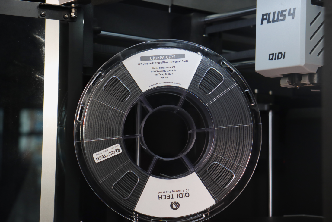QIDI UltraPA-CF25 3D printer spools displayed inside the printer room, showing professional grade black carbon fiber reinforced nylon material, spool storage and setup for industrial printing applications